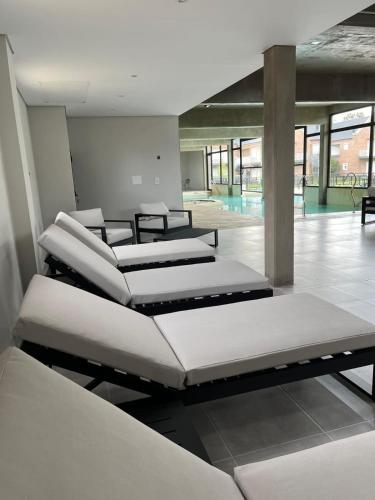 four beds in a room with a pool at Los Robles Apart Hotel l Suites & Spa in Sierra de la Ventana