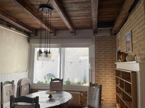 une salle à manger avec une table et une fenêtre dans l'établissement Ma maison au cœur de la ville, à Bergues