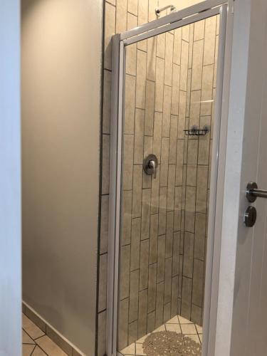 a shower with a glass door in a bathroom at Your Perfect Escape with Breathtaking Lake Views in Pretoria