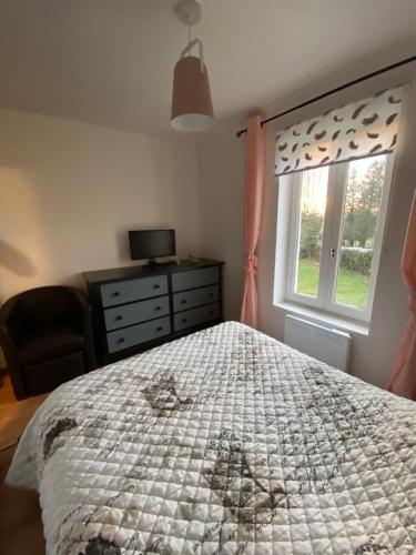 a bedroom with a bed and a dresser and a window at Appartement F1 in Mauriac