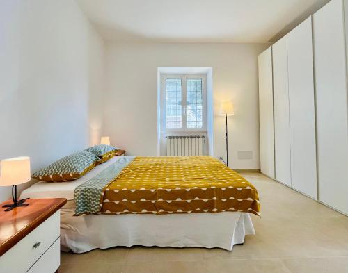 una camera da letto con un letto con una coperta gialla sopra di The seaside villa - Anzio ad Anzio