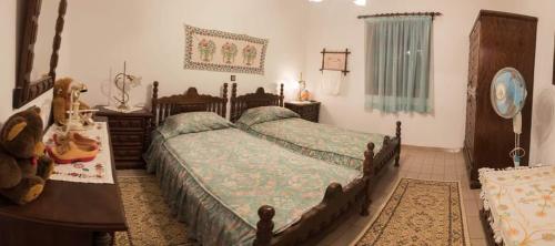 a bedroom with two beds and a dresser and a table at Kolymbia home in Kolymbia