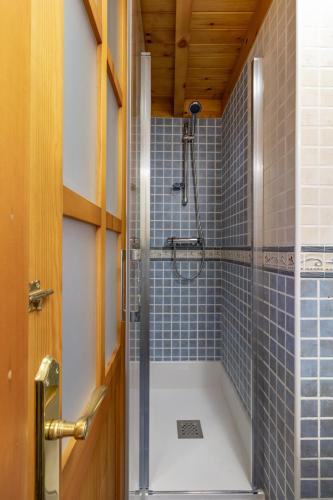 a bathroom with a shower with blue tiles at AH El Escondite de Campomanes VV3485AS in Campomanes