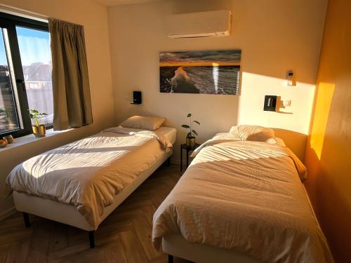 デ・パンネにあるVakantiehuis Zeevonkの窓のある部屋にベッドが2つある