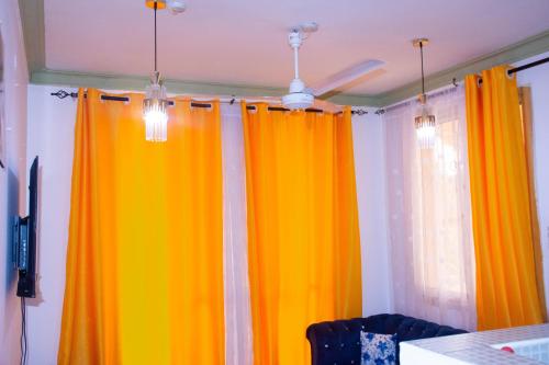 a room with orange curtains and a table at Bamburi Luxury homes II One bedroom apartment in Mombasa