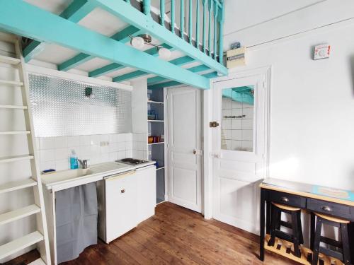 La salle de bains est pourvue de placards blancs et d'un plafond bleu. dans l'établissement Le petit cocon au bord de mer, à Mers-les-Bains