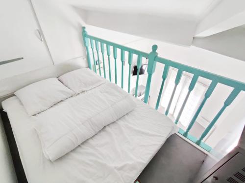 - un lit blanc avec deux oreillers assis sur un escalier dans l'établissement Le petit cocon au bord de mer, à Mers-les-Bains