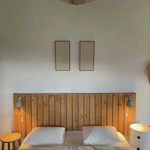 a bedroom with a wooden headboard and two pictures on the wall at San Bartolome Etxea 1 in Ea