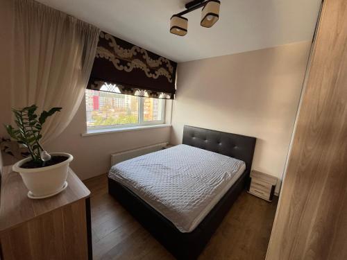 Un dormitorio con una cama y una planta en maceta. en Holiday Home, en Druskininkai