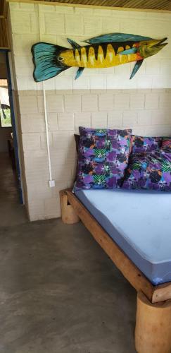a bed in a room with a fish on the wall at FAZENDA BOSQUE DAs PALMEIRAS in Itamaracá
