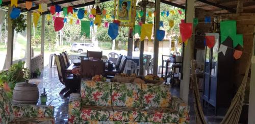 a covered porch with couches and bunting at FAZENDA BOSQUE DAs PALMEIRAS in Itamaracá