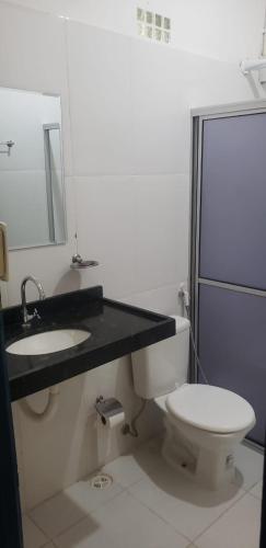 a bathroom with a toilet and a sink and a mirror at FAZENDA BOSQUE DAs PALMEIRAS in Itamaracá