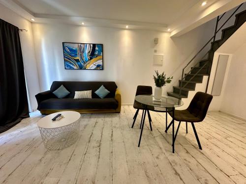 a living room with a couch and a table at 1-bedroom duplex 100m by the sea in Limassol