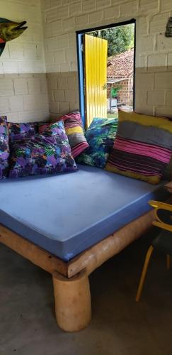 a bed sitting in a room with pillows on it at FAZENDA BOSQUE DAs PALMEIRAS in Itamaracá