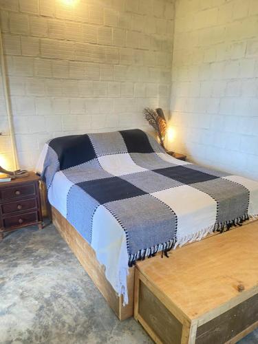 a bedroom with a bed and a wooden table at FAZENDA BOSQUE DAs PALMEIRAS in Itamaracá