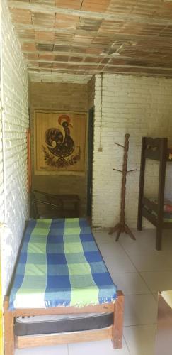 a bed in a room with a painting on the wall at FAZENDA BOSQUE DAs PALMEIRAS in Itamaracá
