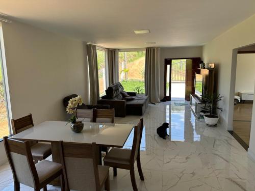 a living room with a table and chairs and a couch at Casa de campo à 10 minutos de São Lourenco mg in Sylvestre Ferraz