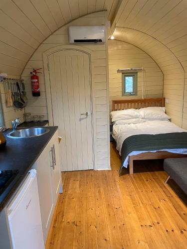 a kitchen with a sink and a bed in a room at Grange Beck Farm Glamping in Kildwick