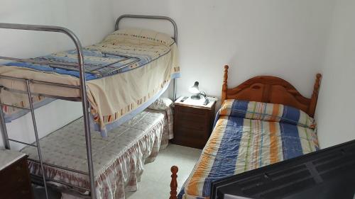 a bedroom with two bunk beds and a night stand at Habitacion Privada Triple Toledo in Toledo