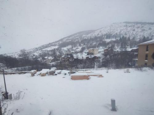 a snow covered yard with cars and a mountain at Chalet NEUF Jacuzzi Terrasse Salle jeux proche Font Romeu in Égat