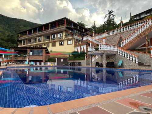 a large swimming pool in front of a building at Finca Hotel Villa Tara in Barbosa