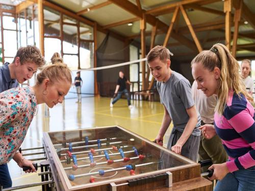 a group of people looking at a pool table at Appartements im Freizeitpark Weissenhäuser Strand in Weissenhäuser Strand