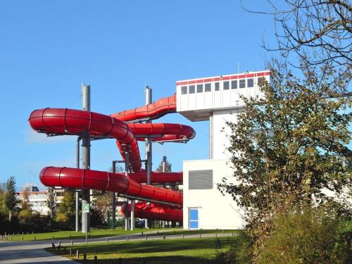 a red water slide in front of a building at Appartements im Freizeitpark Weissenhäuser Strand in Weissenhäuser Strand