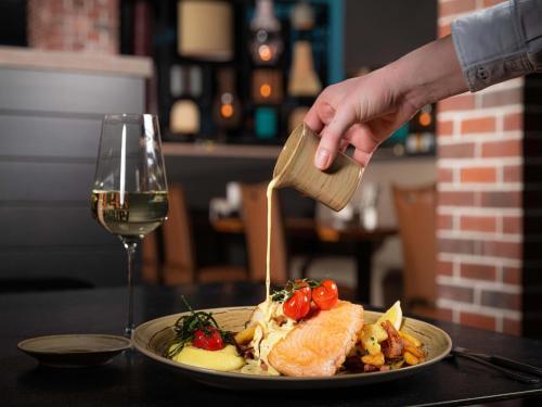 a person holding a wooden spoon over a plate of food at Appartements im Freizeitpark Weissenhäuser Strand in Weissenhäuser Strand