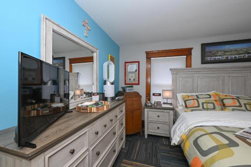 a bedroom with a bed and a television on a dresser at Berrodin Bed & Breakfast in Akron