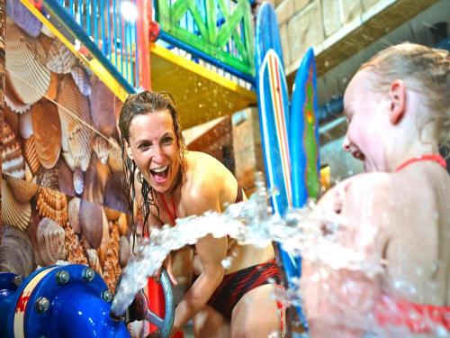 a woman is playing in a water park at Appartements im Freizeitpark Weissenhäuser Strand in Weissenhäuser Strand