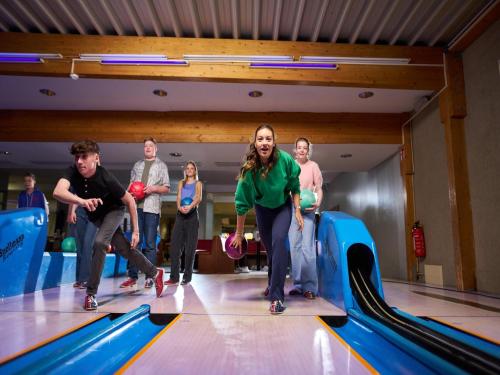 a group of people playing in a bowling alley at Appartements im Freizeitpark Weissenhäuser Strand in Weissenhäuser Strand