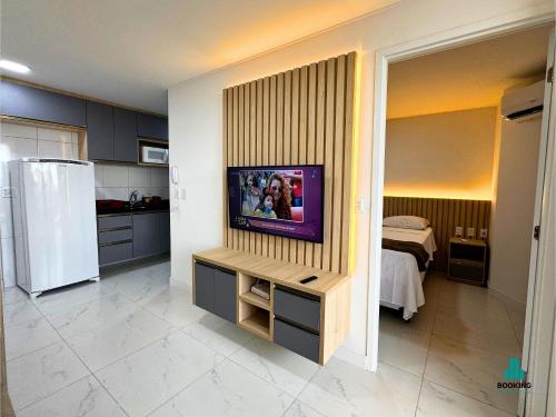 a kitchen with a tv on a wall at Aquarius Style by Holiday Stays in Fortaleza