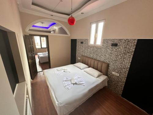 a small bedroom with a bed with white sheets at batummetropol hotel in Batumi