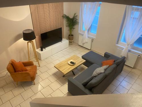 un salon avec un canapé et une télévision dans l'établissement L'escapade Douaisienne, à Douai