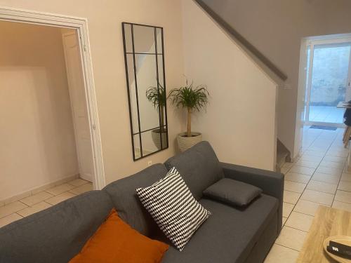 - un salon avec un canapé gris et un miroir dans l'établissement L'escapade Douaisienne, à Douai