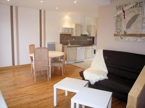 un salon avec un canapé et une table dans l'établissement La Petite Maison, à Port-en-Bessin-Huppain