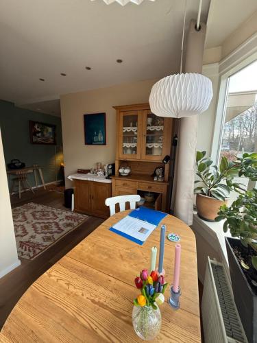 a dining room with a wooden table with flowers in a room at Bij Flora in Beekbergen