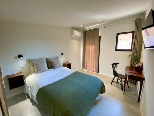 une chambre d'hôtel avec un grand lit et un bureau dans l'établissement Chambre d'Hôtes Dahlia - Boutenac, à Boutenac