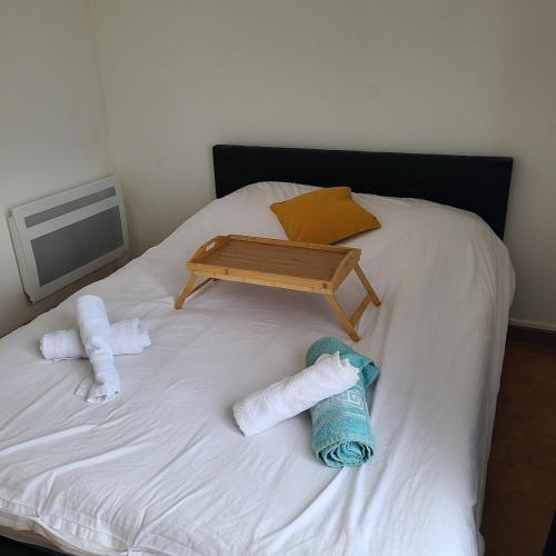 - un lit avec 2 serviettes et un plateau dans l'établissement Appartement Morlaix pres de la gare avec 2 chambres, à Morlaix