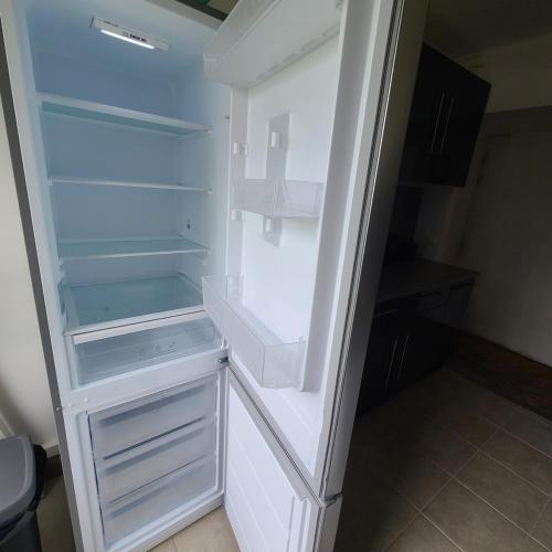 un réfrigérateur vide avec une porte ouverte dans une pièce dans l'établissement Appartement Morlaix pres de la gare avec 2 chambres, à Morlaix