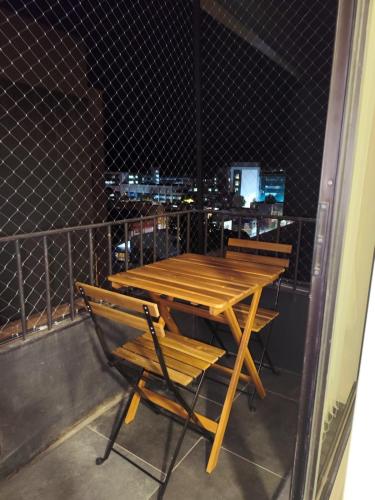 a wooden table and chairs on a balcony at Apartamento en Concepción con estacionamiento privado in Concepción