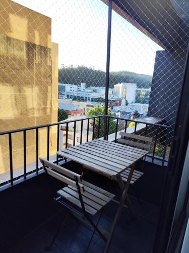 a wooden table and bench on a balcony with a view at Apartamento en Concepción con estacionamiento privado in Concepción