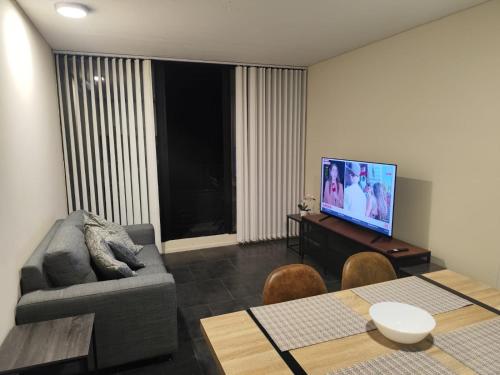 a living room with a couch and a flat screen tv at Apartamento en Concepción con estacionamiento privado in Concepción