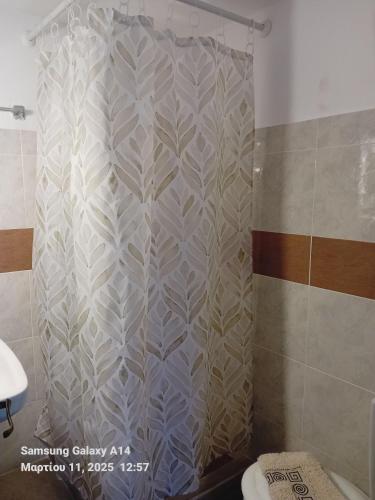 a shower curtain in a bathroom with a toilet at Giorgos House in Mythimna