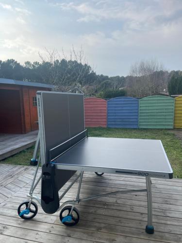 a ping pong table sitting on top of a deck at Maison bassin d'Arcachon 8 personnes, SPA, promo août in Le Teich