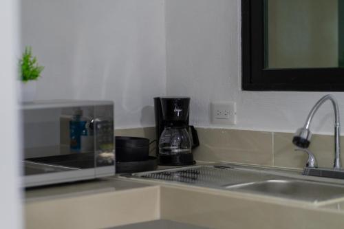 a kitchen counter with a sink and a coffee maker at Peregrina 270 Departamentos in Motul de Felipe Carrillo Puerto