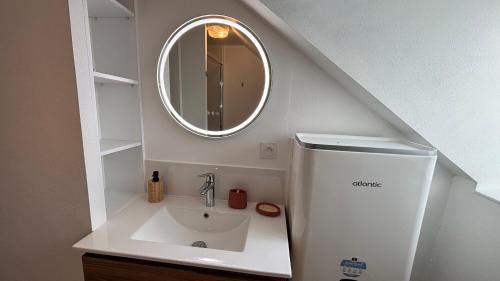 une salle de bain avec un lavabo et un miroir dans l'établissement L'escale - charmant studio à Laval, à Laval