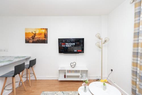 a living room with a tv on a white wall at Permazing in Southampton