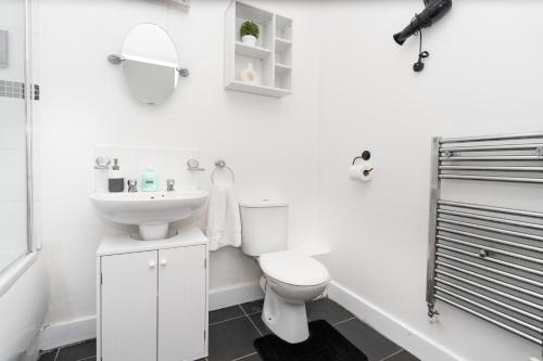 a white bathroom with a toilet and a sink at Permazing in Southampton