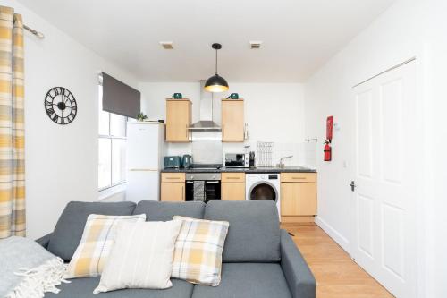 a living room with a couch and a kitchen at Permazing in Southampton
